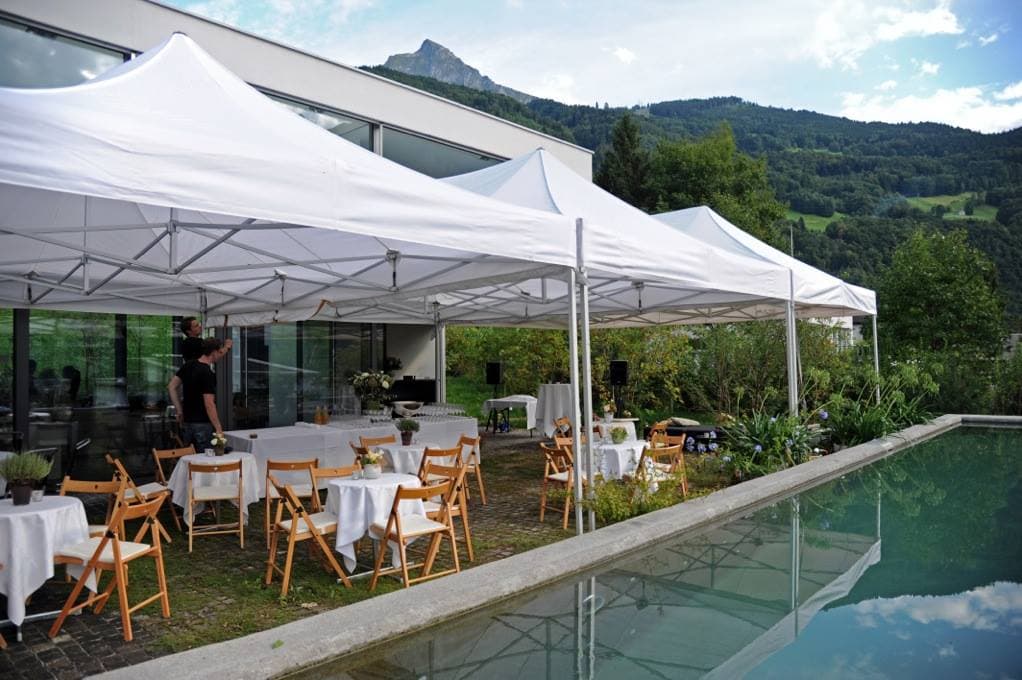 White pavilions along a pool at an event
