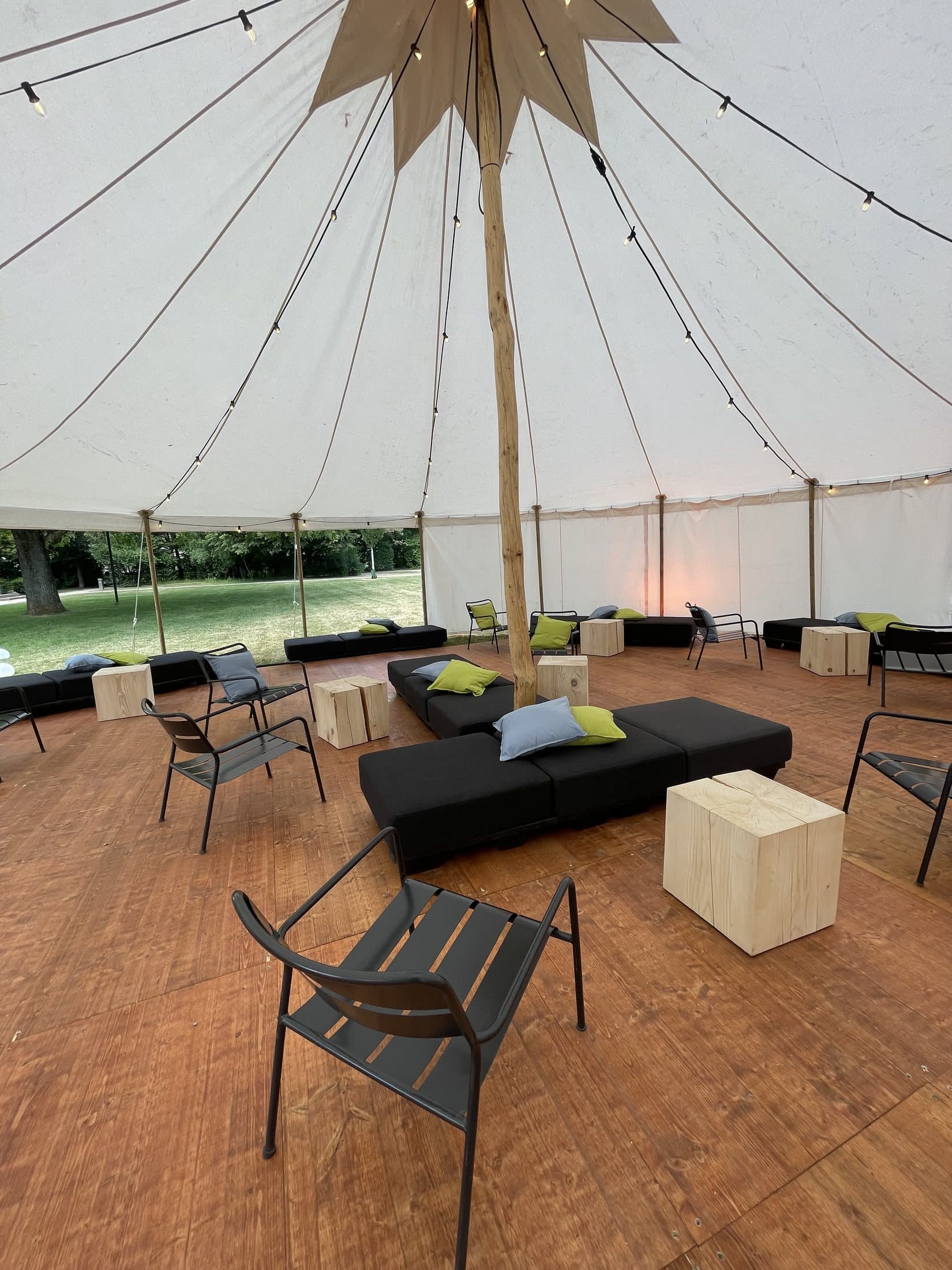 View from above onto wooden flooring and lounge furniture in the tent