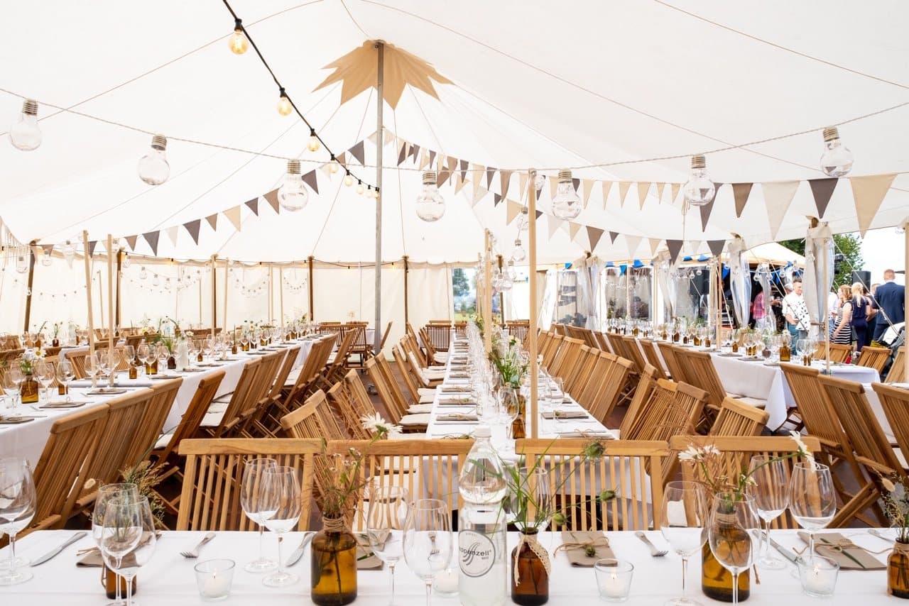 Fabric tent with bunting above the laid tables
