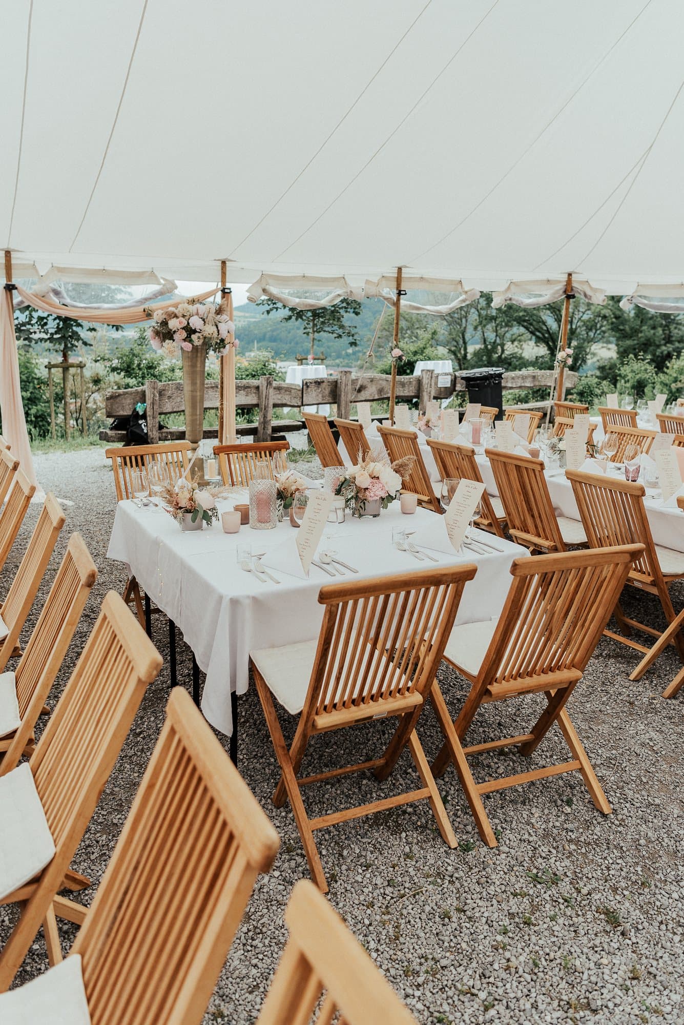 Laid table in the fabric tent with a view over the green