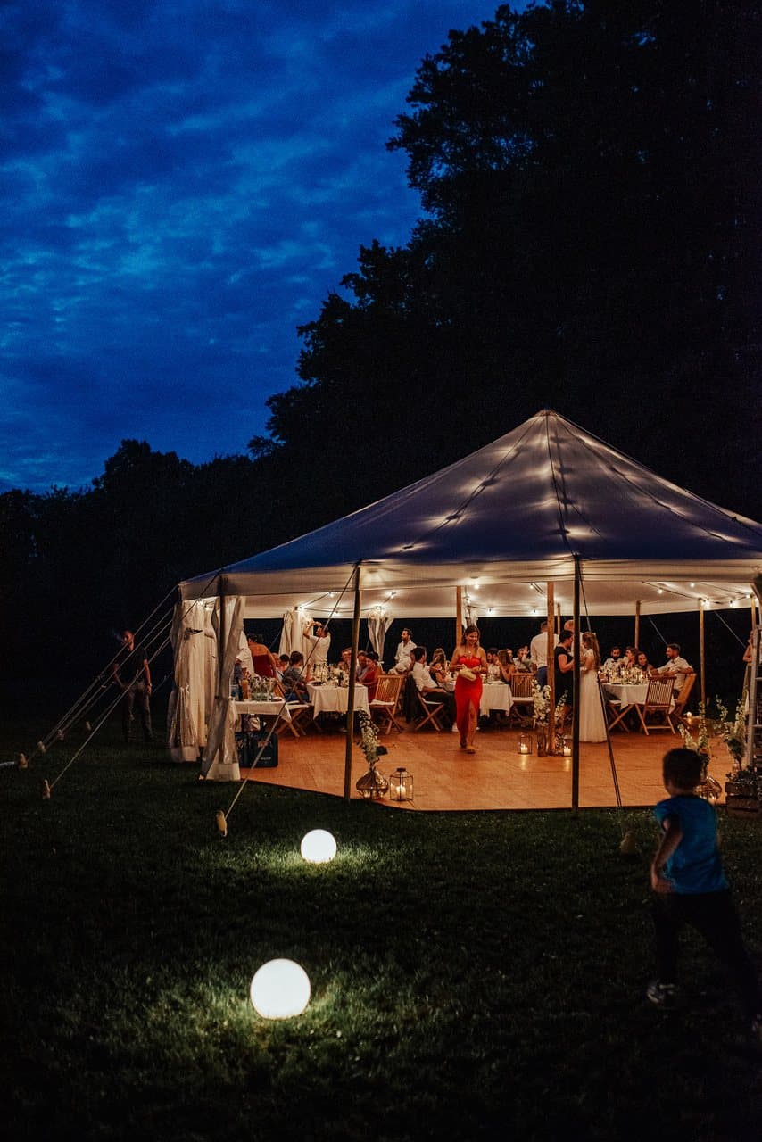 Lit fabric tent at dusk on a meadow