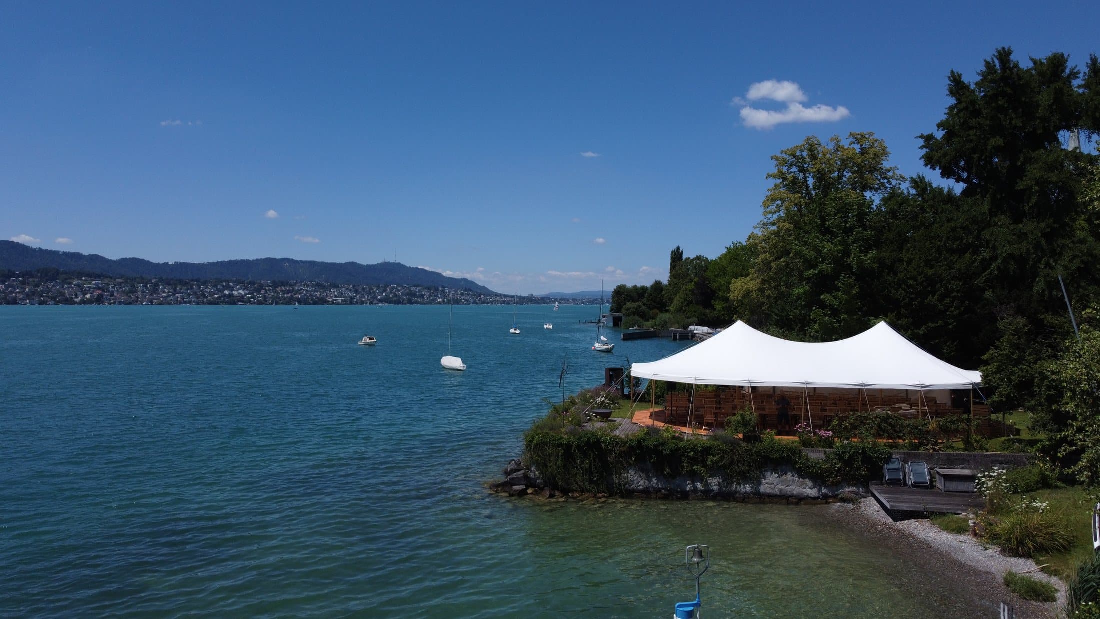 White tent on a spit of land on Lake Zurich near Erlenbach