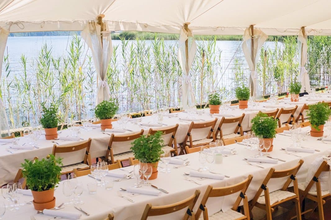 Laid tables in the tent with an open side towards Lake Sarnen